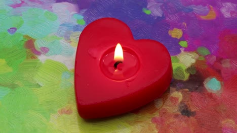 luz de una vela en forma de corazón roja en la paleta de colores de un pintor