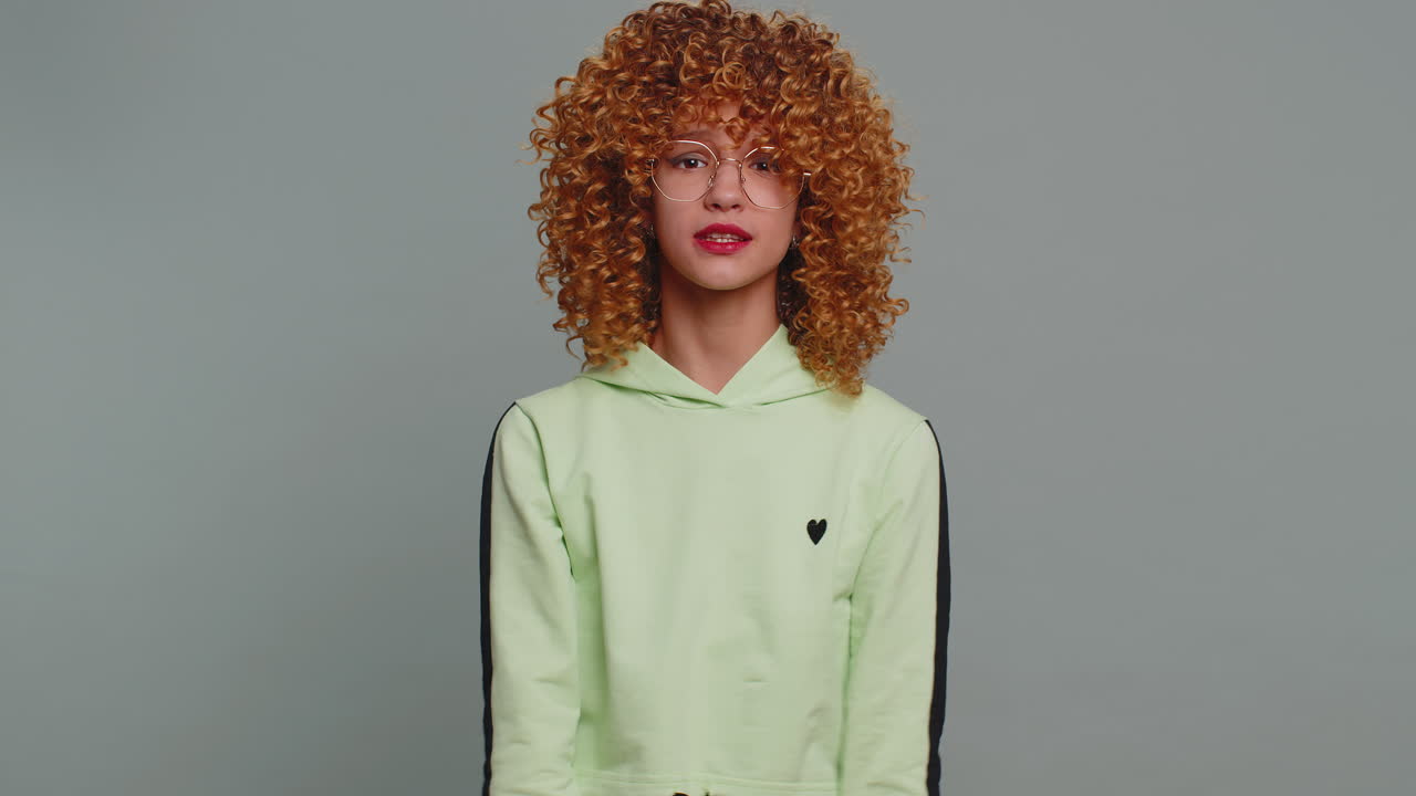 Young teenager child girl shakes finger and saying no be careful avoid danger mistake disapproval