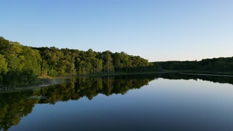 Antena:-Toma-Panorámica-Hacia-Adelante-Con-Drones-Del-Reflejo-Del-Bosque-En-Un-Lago-Tranquilo