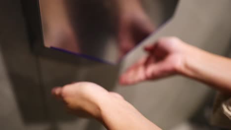 secado de manos bajo un secador automático de manos