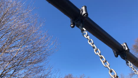 Empty-toddler-swing-set-in-park,-winter-time