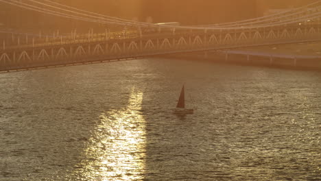 aerial view of a sailboat on the east river at sunset