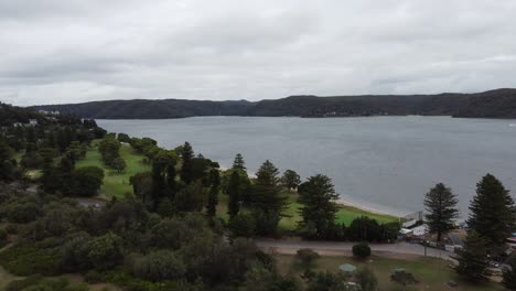 Aerial-view-of-a-green-park-with-a-bay-in-the-background