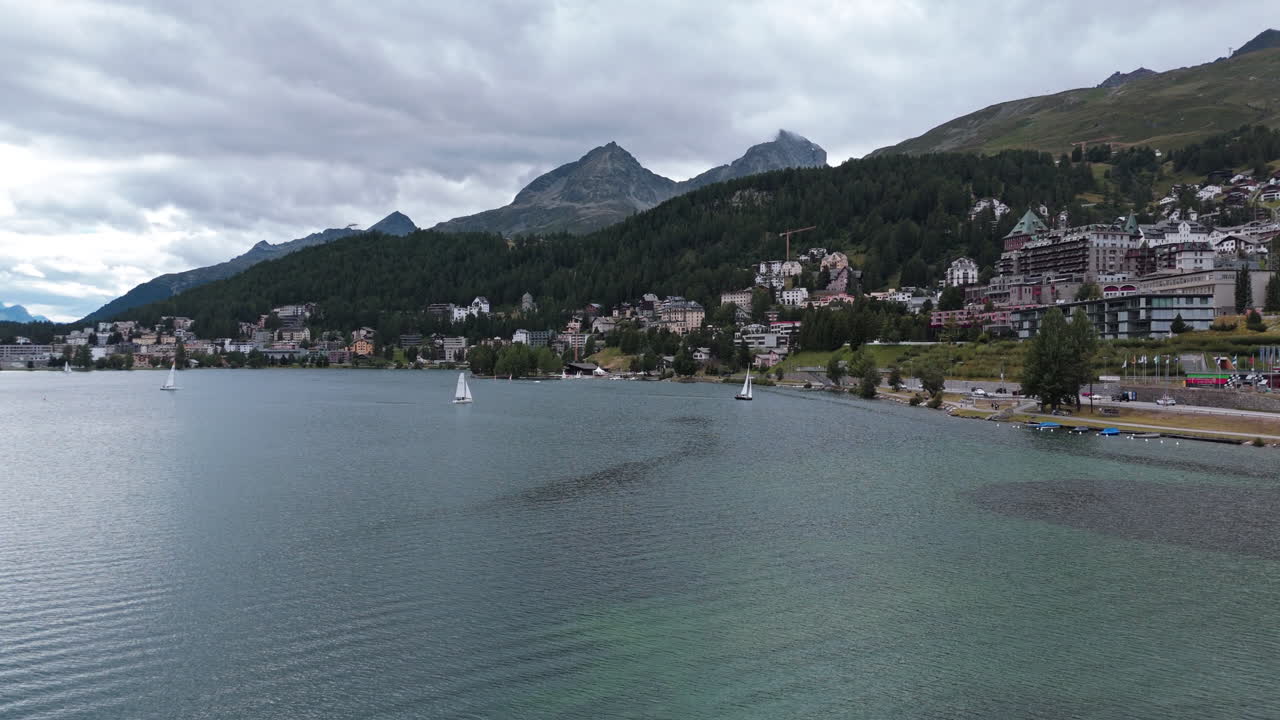 Scenic view of St. Moritz lake with mountains and cloudy sky