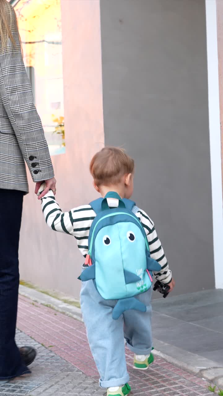 Adult and Toddler Walking Hand in Hand on City Street