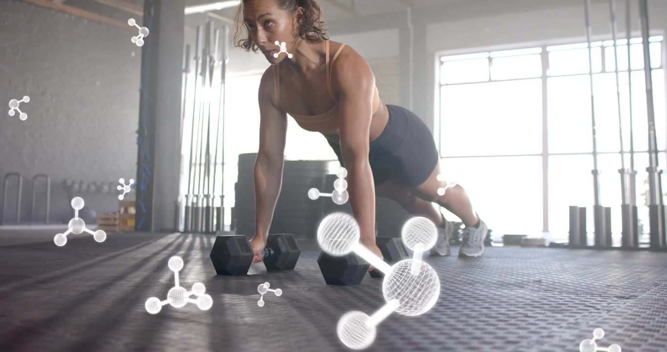 Woman engaging core on dumbbells and pressing up for fitness as molecular graphics pulsating