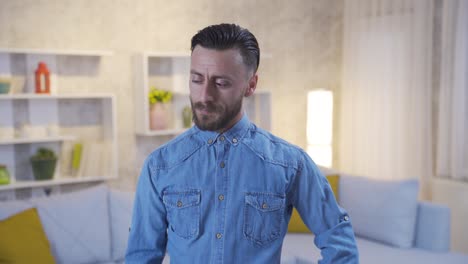 the man in the thoughtful profile at home looks around, thinks about his loneliness, thinks about his grief.