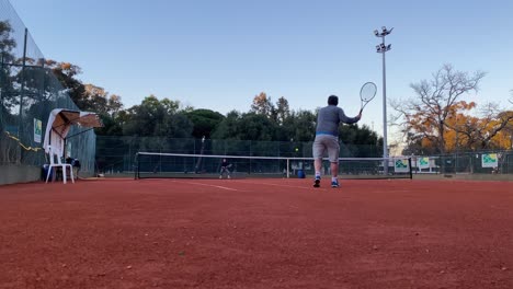 man playing tennis in a hardcourt with a partner in lisbon, portugal