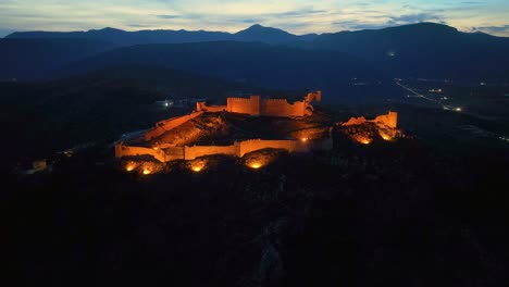 vista de avión no tripulado de un castillo iluminado en una montaña al anochecer