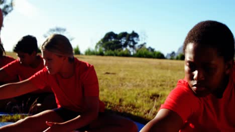 Trainer-instructing-kids-while-exercising-in-the-boot-camp