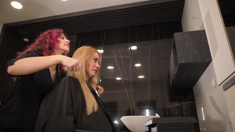 young blond woman getting haircut by hairdresser in the beauty salon hair style concept. young blond woman getting haircut by hairdresser in the beauty salon. hair style concept. high quality footage