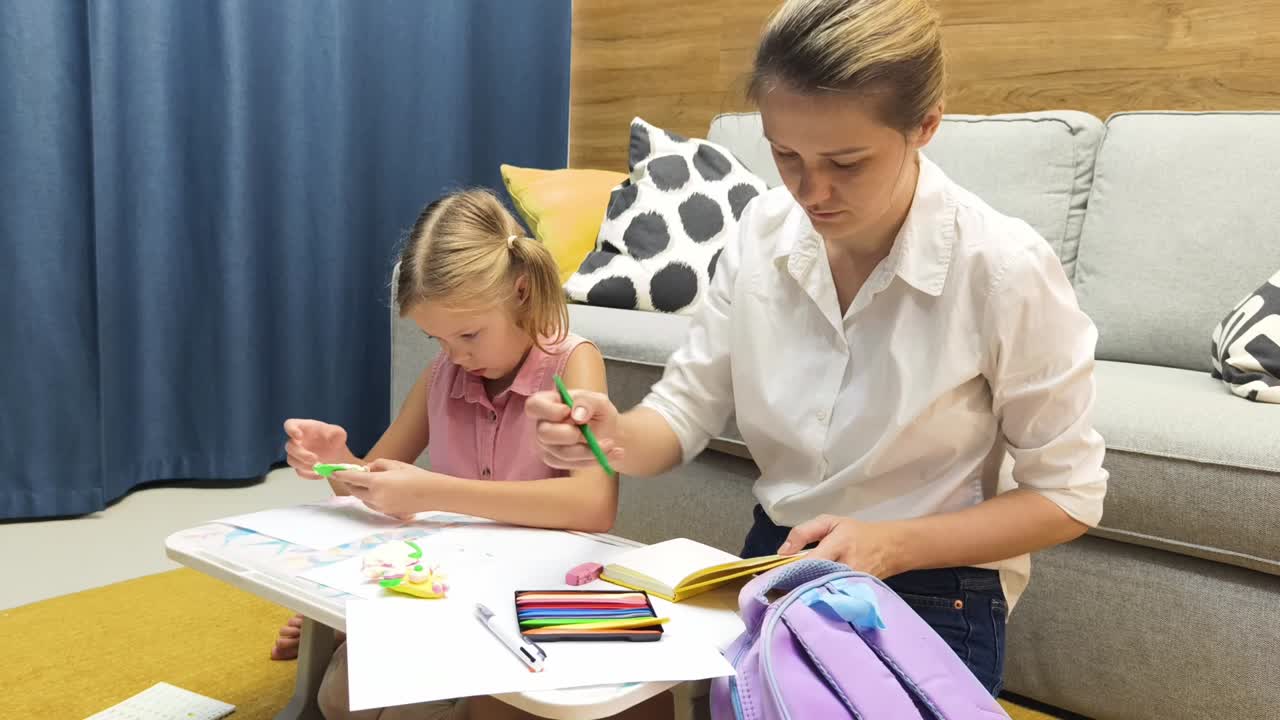madre ayudando a su hija con la tarea de arte en casa