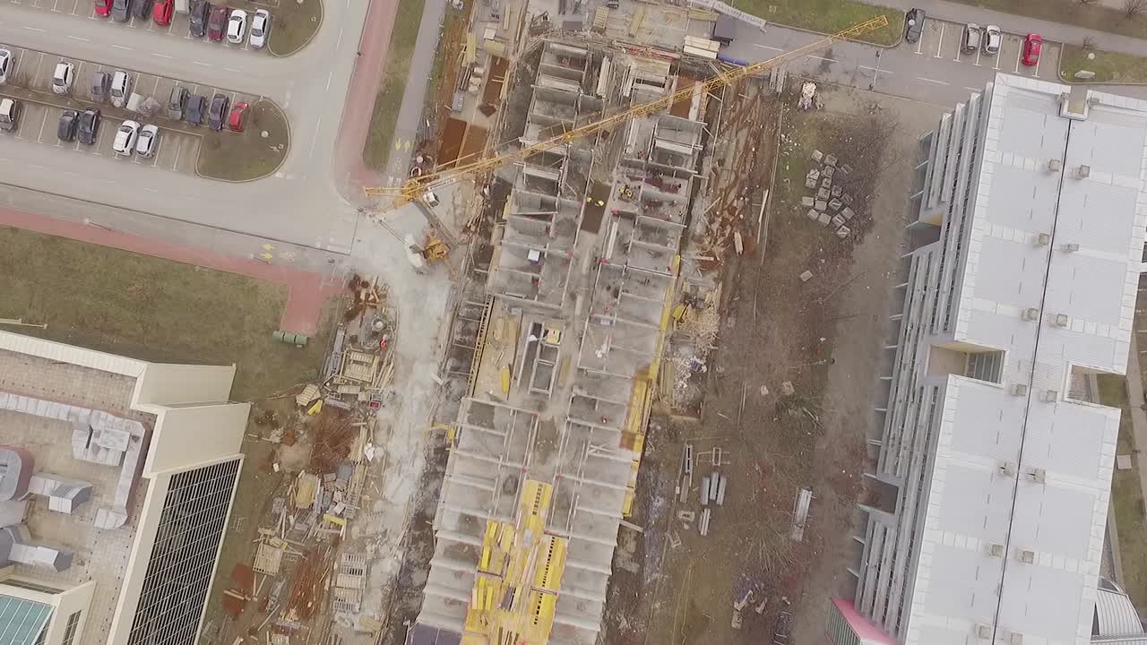 tiro directo hacia abajo de un sitio de construcción con grúas, drones