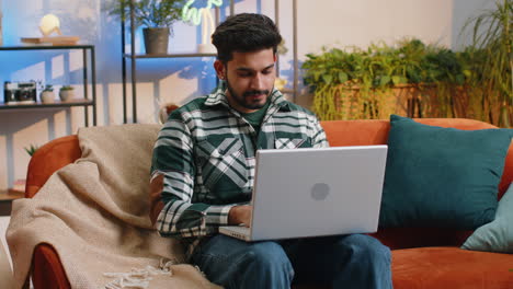 Indian-man-freelancer-opens-laptop,-starts-working-education-sends-messages,-makes-online-purchases