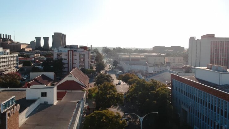 Ripresa drone in ascesa di una zona cittadina trafficata a Bulawayo, Zimbabwe, al tramonto