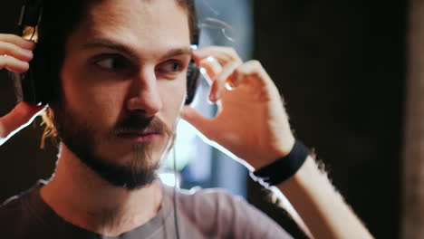 joven hipster con barba escuchando música alrededor de las paredes de ladrillo el viento susurra suavemente el