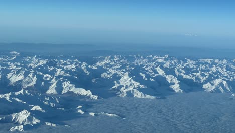 Explorando-Majestuosas-Montañas-Nevadas-En-Un-Claro-Día-De-Invierno-Desde-Arriba