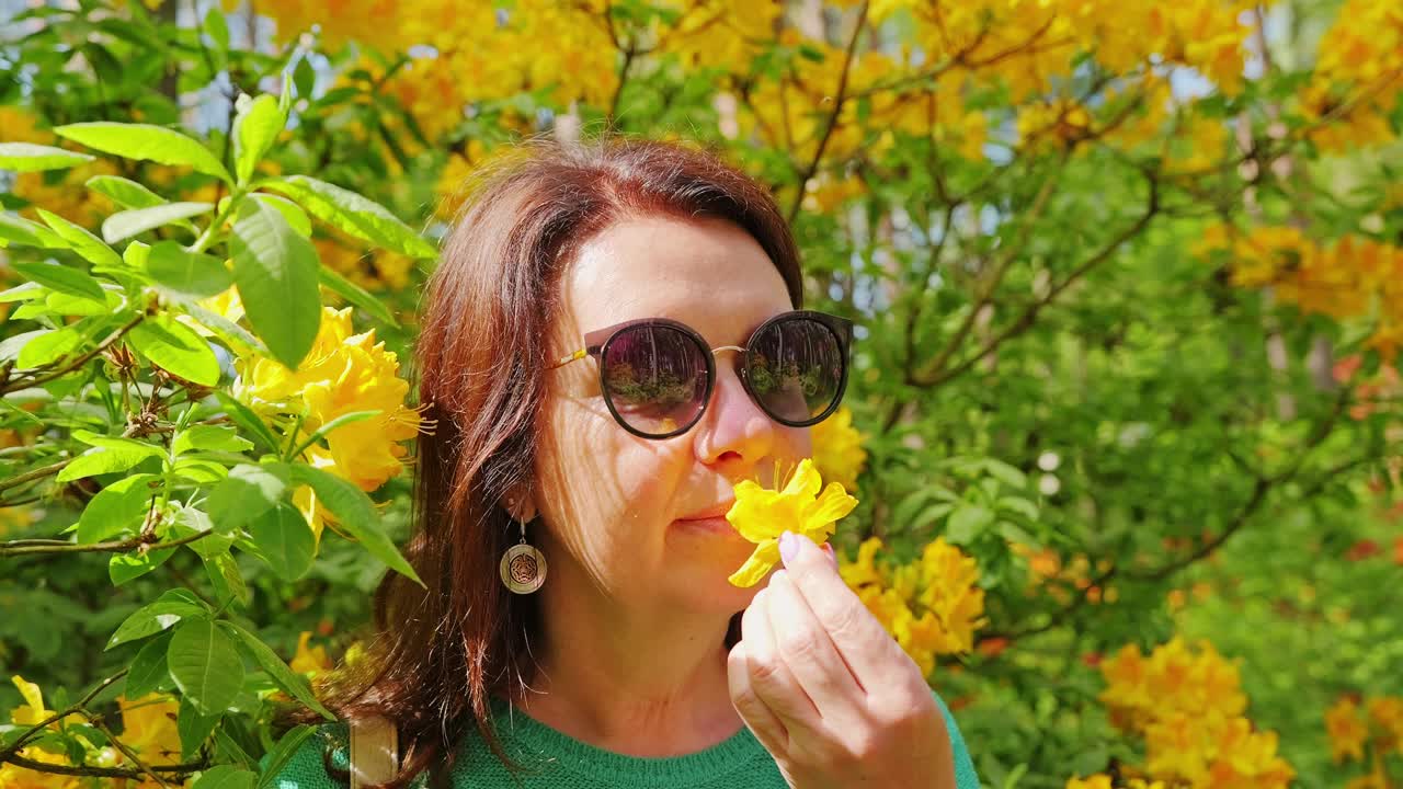 Donna matura che tiene delicatamente un fiore che simboleggia crescita, equilibrio, perimenopausa.