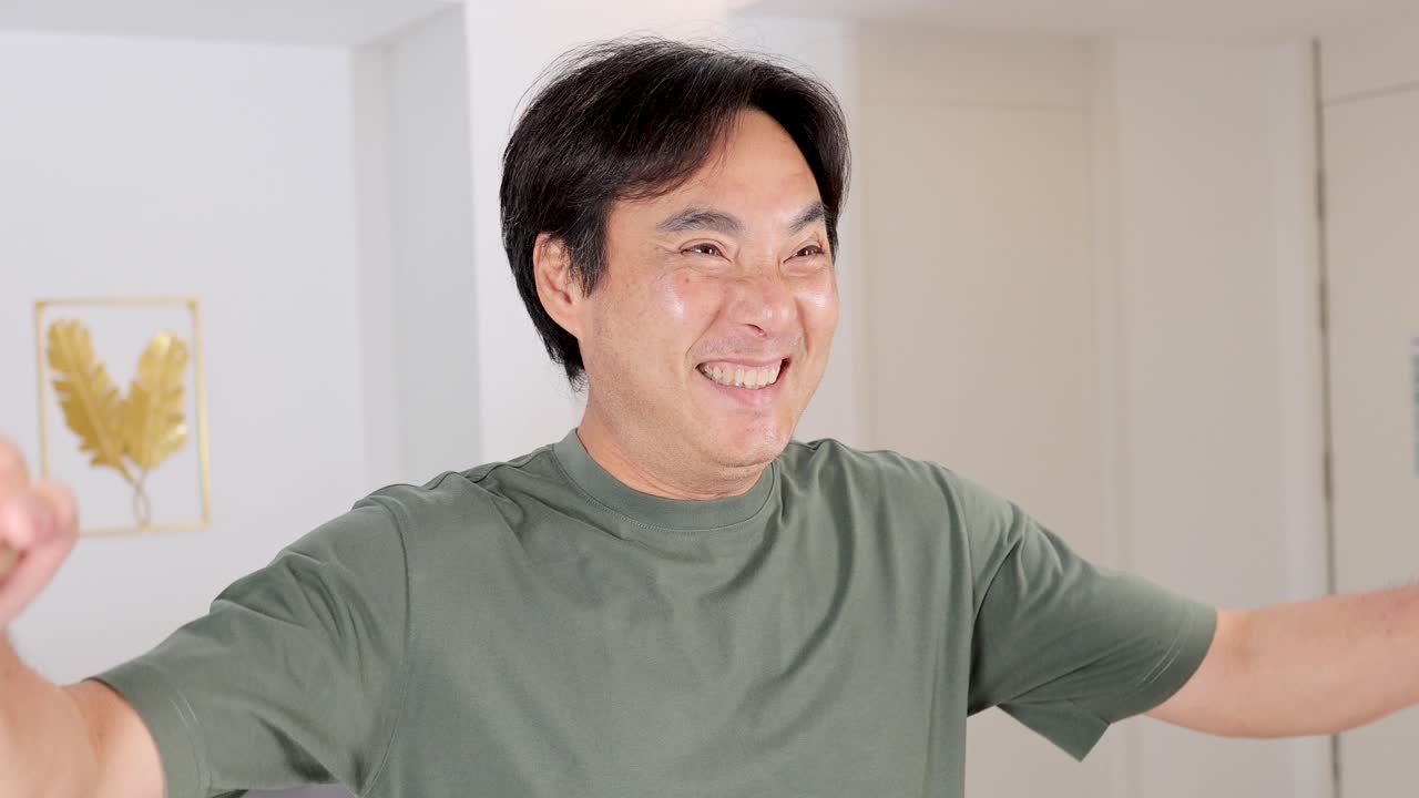 A man expresses happiness with energetic gestures in a well-lit room, conveying excitement and positivity