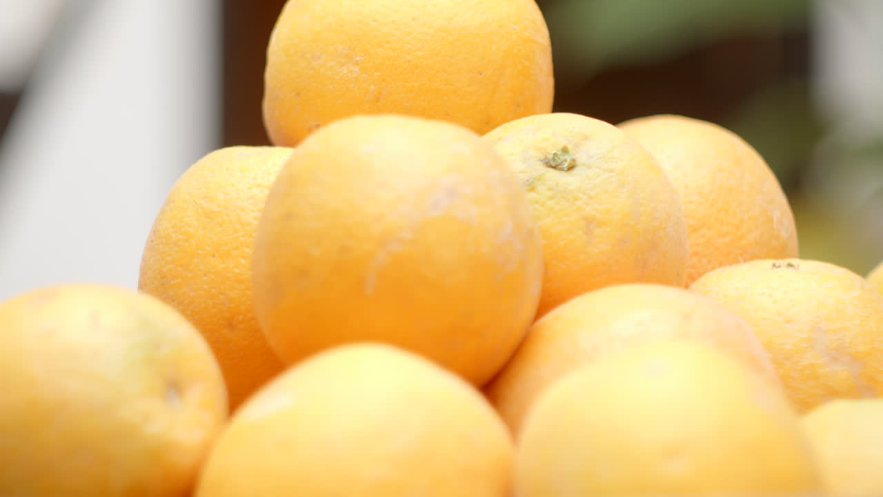 cerca de las naranjas frescas y jugosas amontonadas, enfoque suave, órbita de paralaje