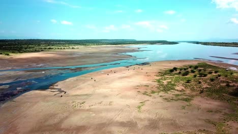 vista aérea de personas montando motocicletas cerca del lago magadi en kenia durante el día - disparo de drones