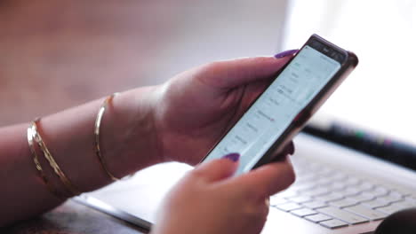 Close-up-of-a-business-woman-scrolling-through-her-phone