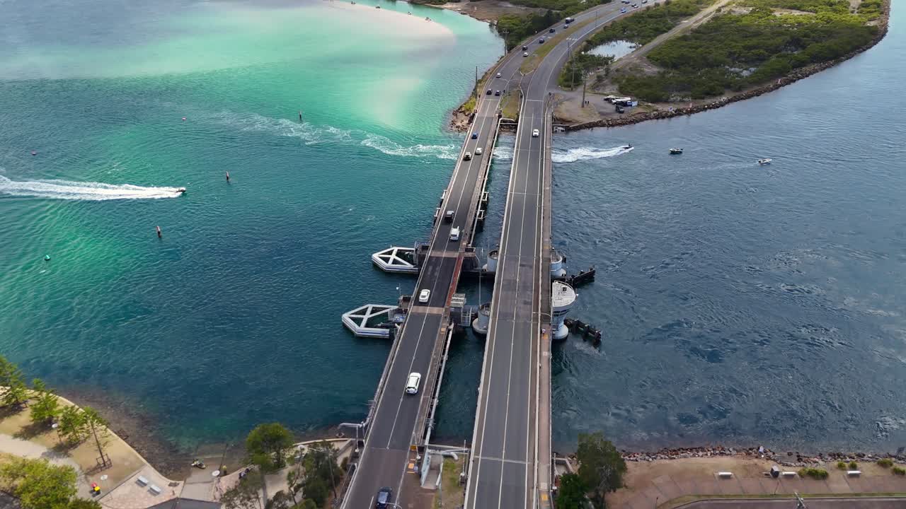 Drone mediumg overview of Swansea Bridge over blue water and tidal currents Australia