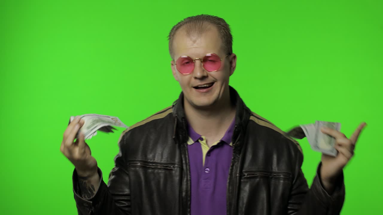 feliz ganador de la lotería, feliz hombre de rock bailar y celebrar la victoria. mantener el dinero en efectivo en sus manos