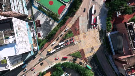 birds eye aerial view looking down over kowloon city highrises footbal pitch and highway traffic hong kong