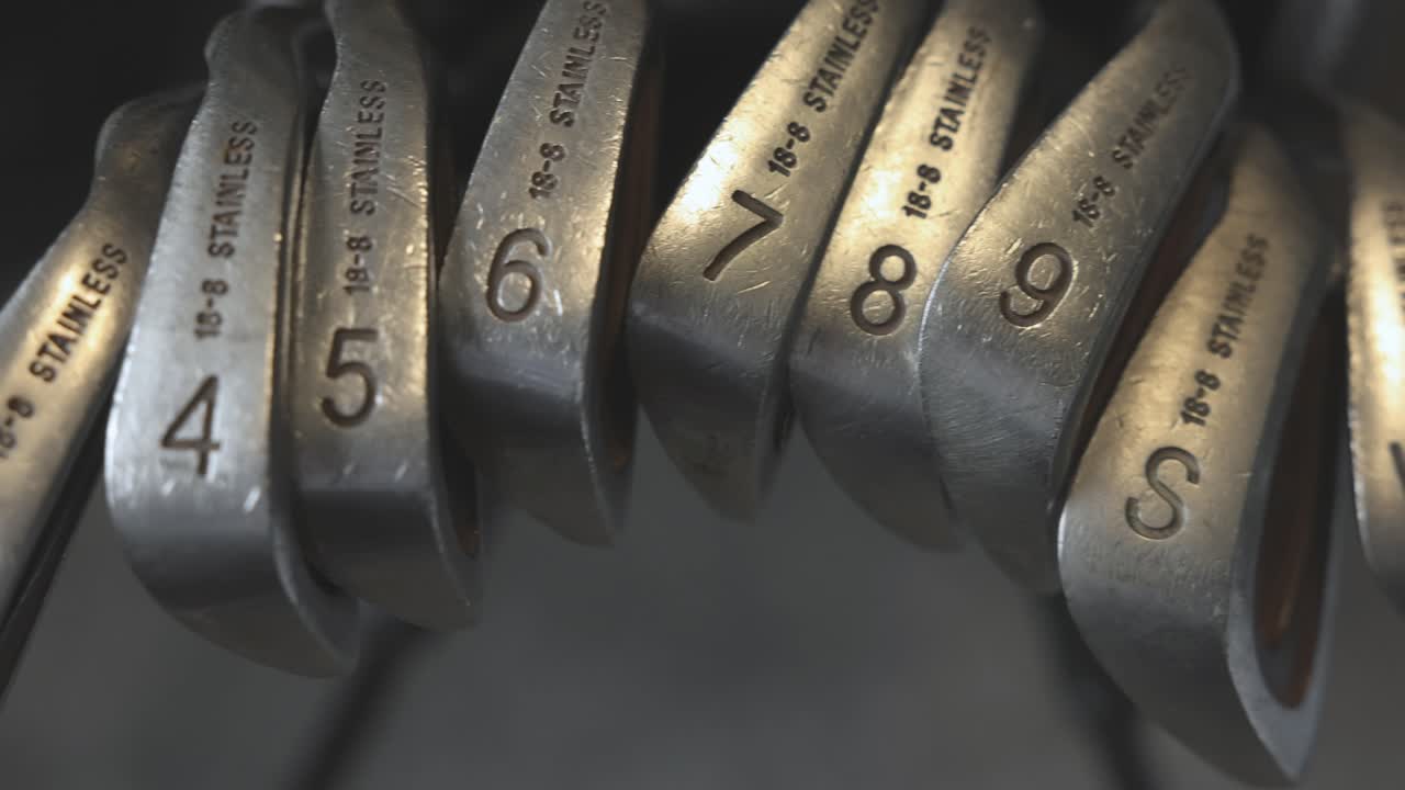slow panning shot of a full set of golf irons and wedges in a golfers bag