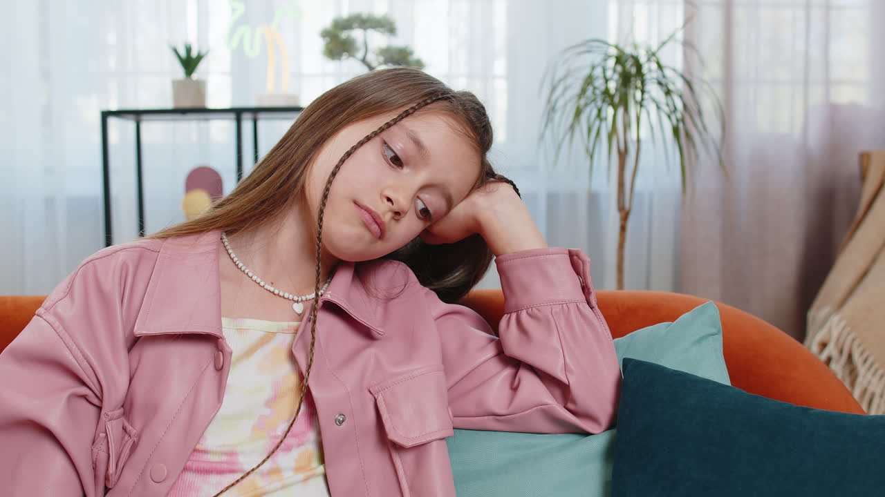 Tired preteen teenage kid thinking dreaming imagining leaning head on hand boredom disinterest