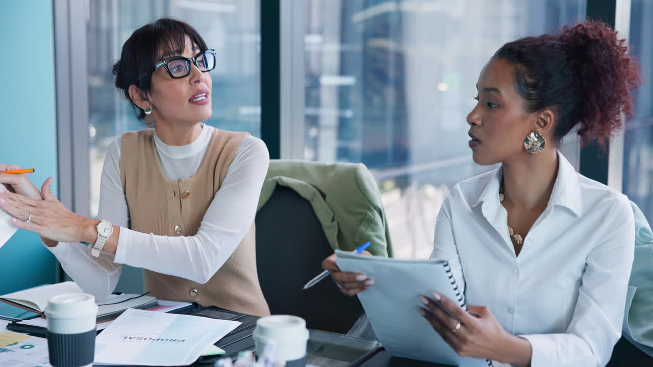 Zwei Geschäftsfrauen, die in einem modernen Büro einen Vorschlag besprechen