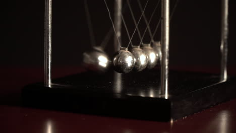 newton's cradle over black background, view from one side slow motion