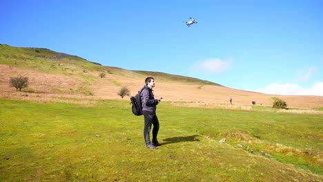 piloto de avión no tripulado volando una uas en el parque nacional brecon beacons en un día soleado, gales