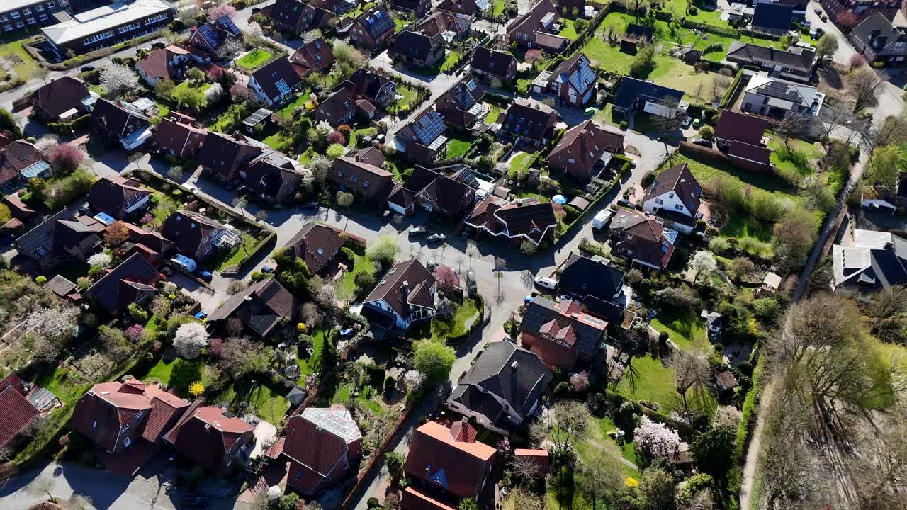 American city neighborhood during sunny day in spring. Drone flight over peaceful and calm housing area in spring. Streets and roads between homes. Top down.