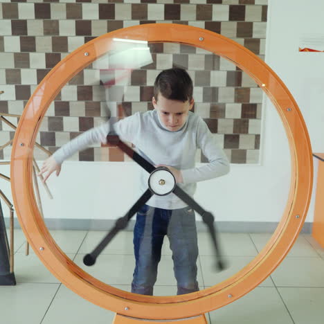 child looks at the perpetual motion machine in the children's scientific museum. concept of physics square video