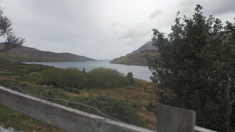 shot going over fence looking at a lake in the highlands of ireland with mountains and trees
