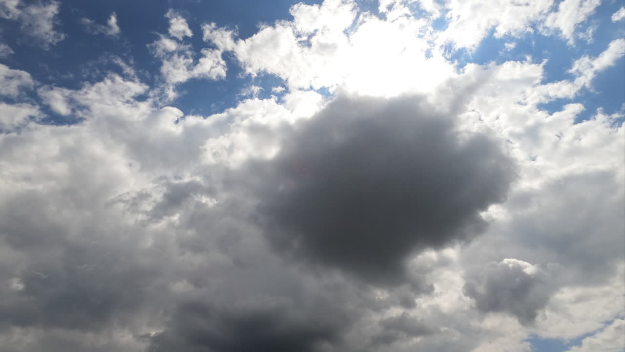 Grey cumulus clouds covering the sky. Dull cloudscape gathering for rain. Low angle view timelapse.