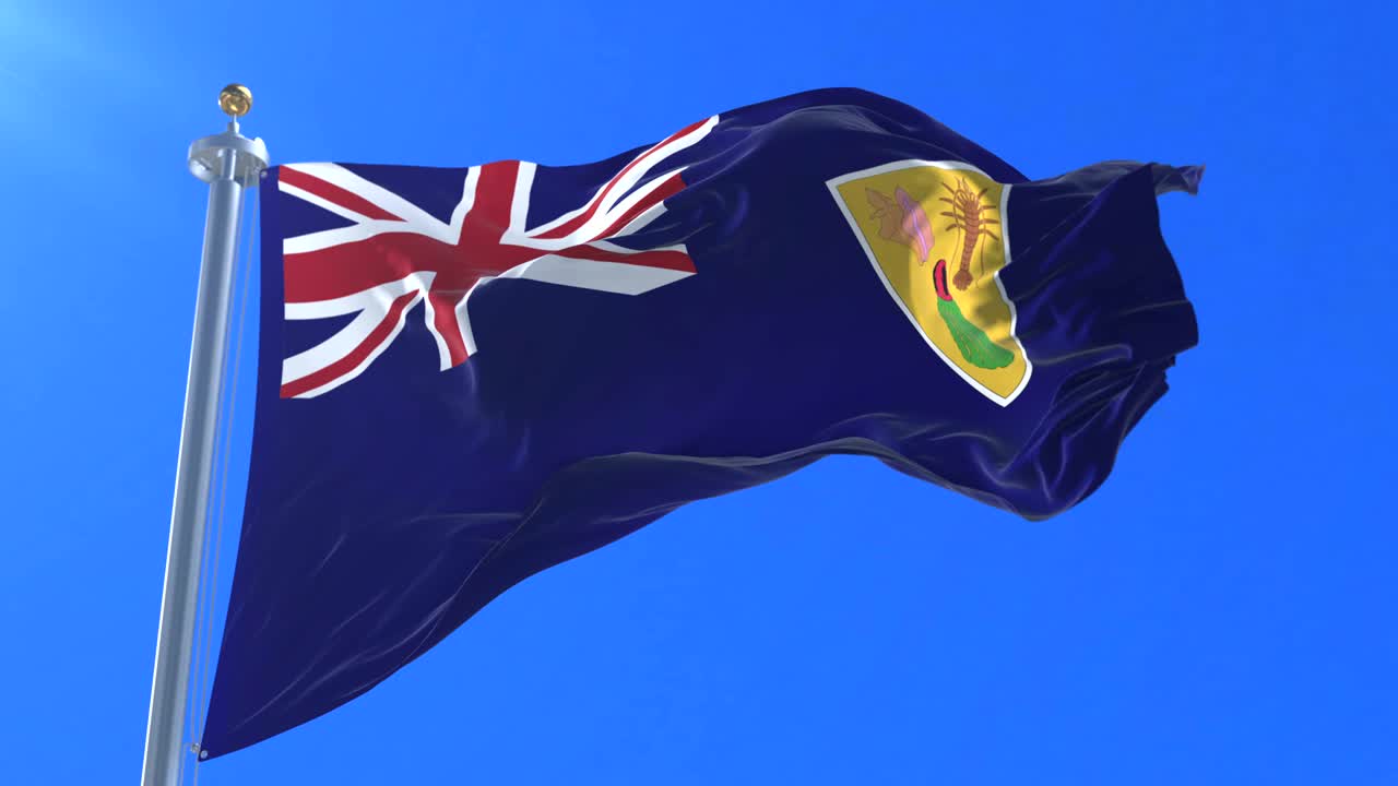 Flag of the Turks and Caicos Islands waving at wind with blue sky, loop