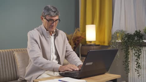 Old man chatting on laptop.
