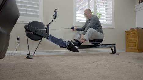 senior man finishes his workout on a rowing machine