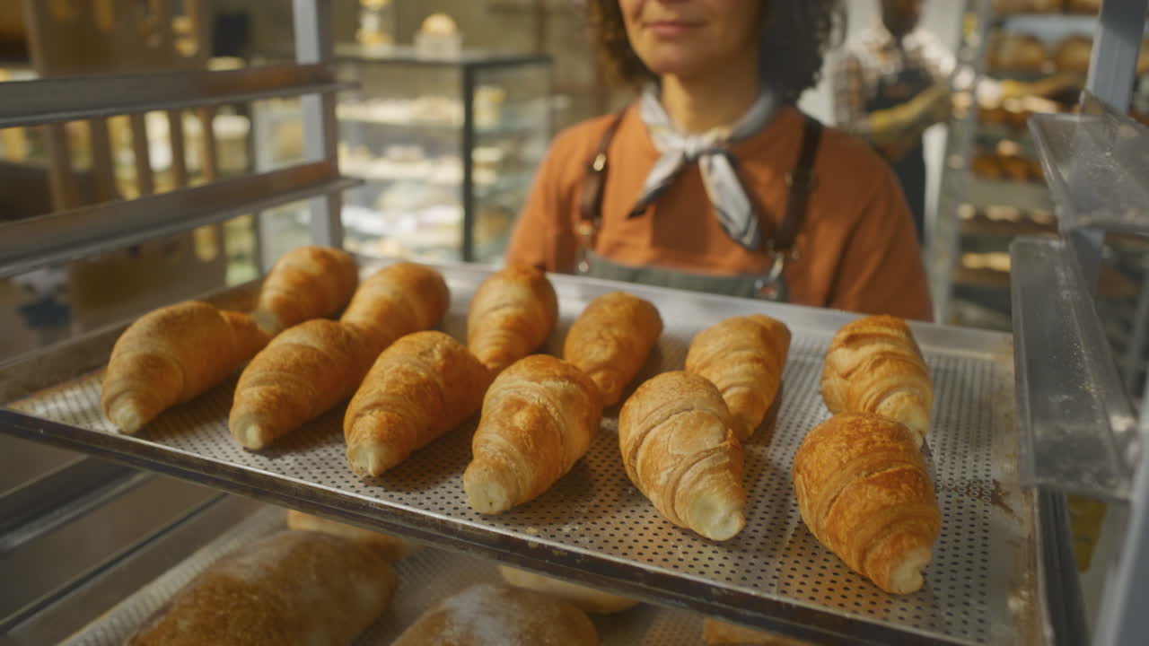 Donna che espone croissant in una pasticceria