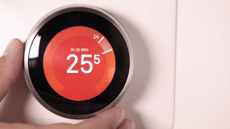 a person increasing the temperature on a smart thermostat on celsius scale on a slow motion