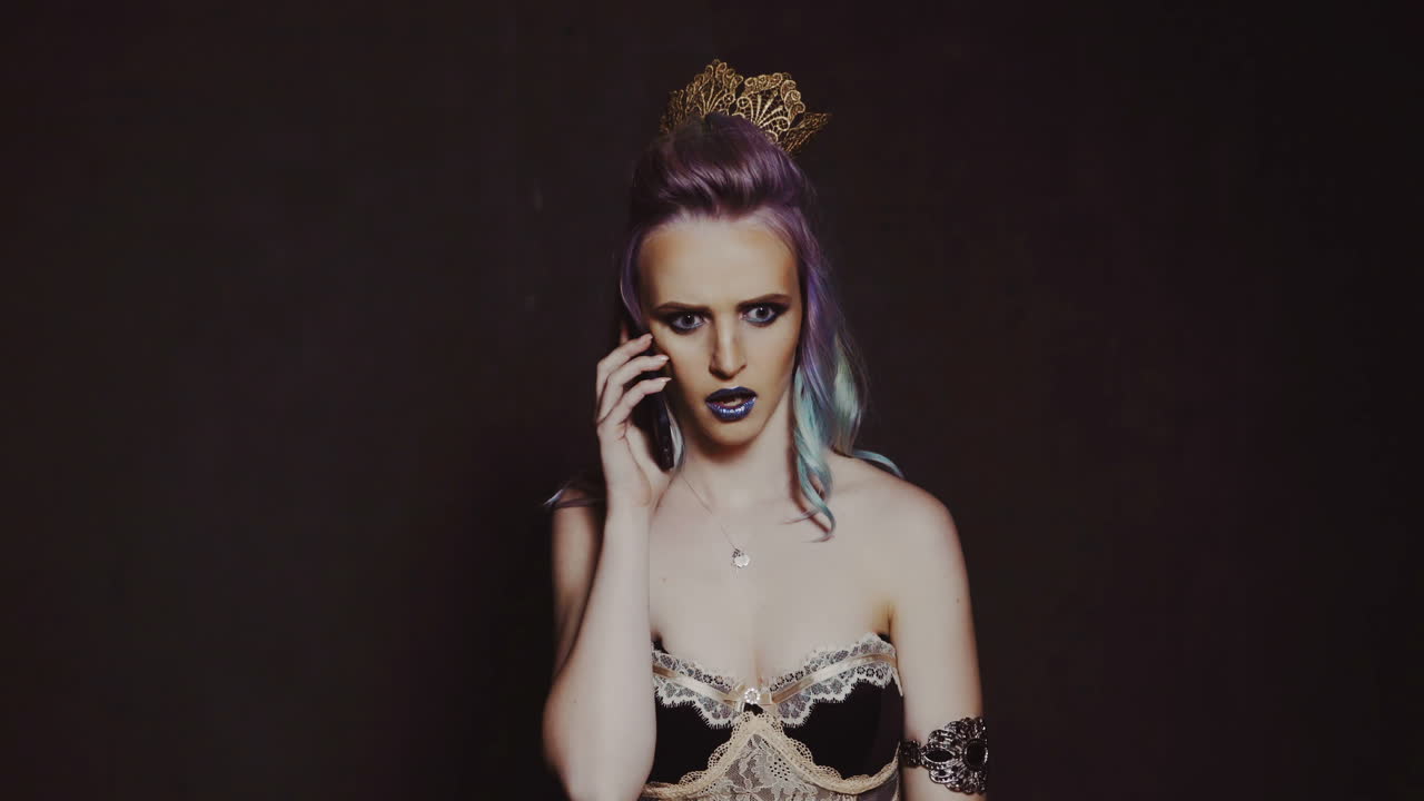 Giovane donna bellissima con smartphone. Bella donna che ride parla al telefono in piedi su sfondo nero.