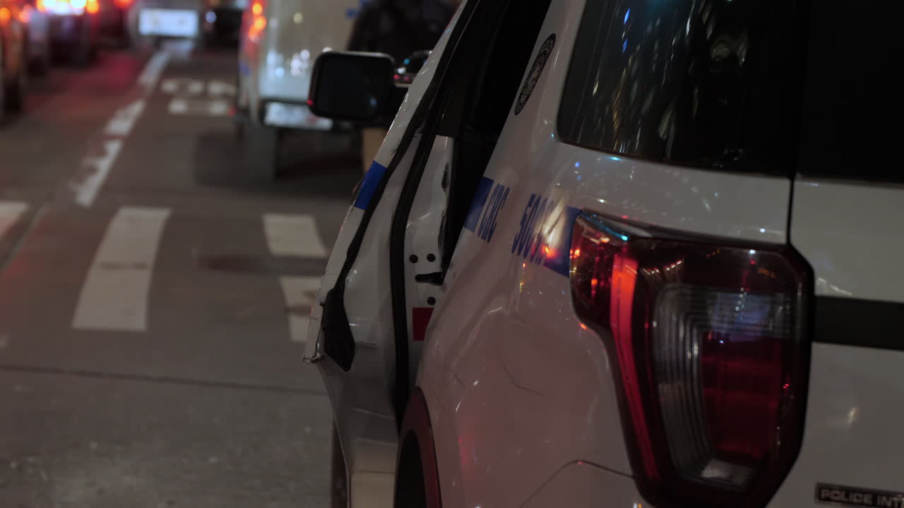 Close up of back driver side NYPD SUV in evening,parked on side of road, showing damage to the rear door and quarter panel.