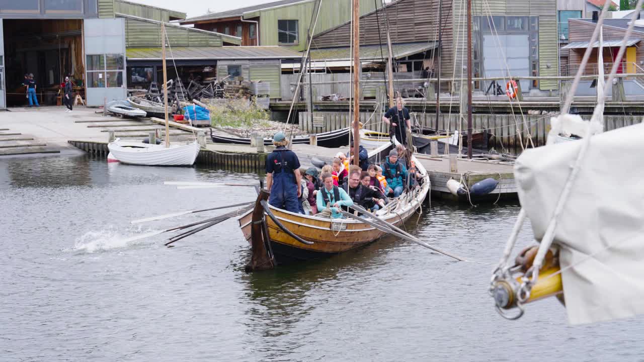Group of people rowing a wooden boat in a canal