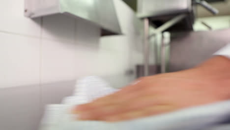 chef wiping down surface and spraying detergent