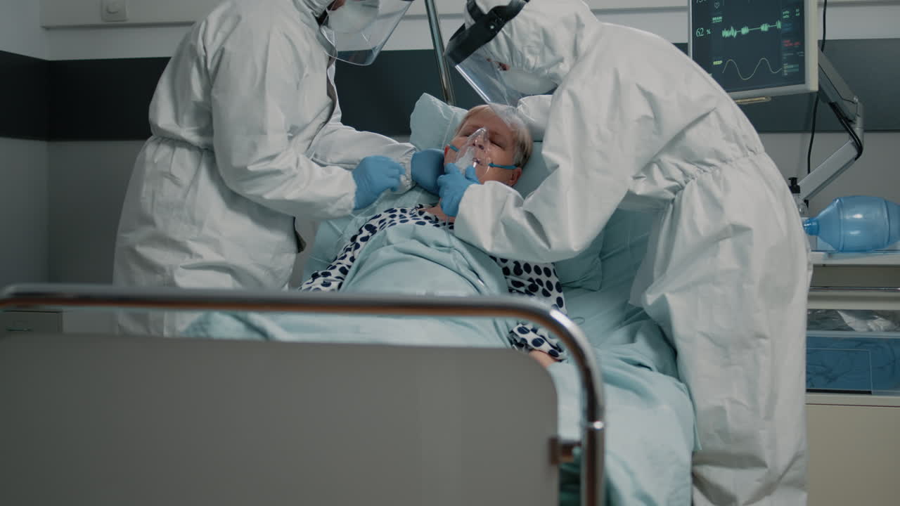 Medical team with protective uniforms using oxygen tube