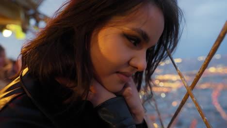 Portrait-of-a-beautiful-young-brunette-woman-looking-at-Paris-cityscape-from-the-Tour-Eiffel,-France,-at-dusk