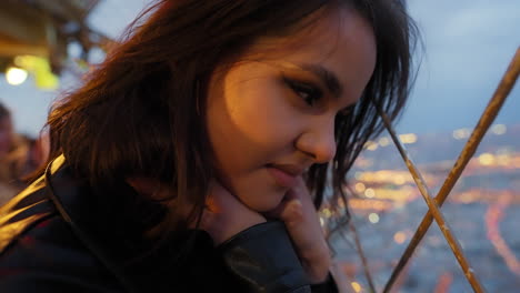 retrato de una hermosa joven mujer morena mirando el paisaje urbano de parís desde el tour eiffel, francia, al anochecer
